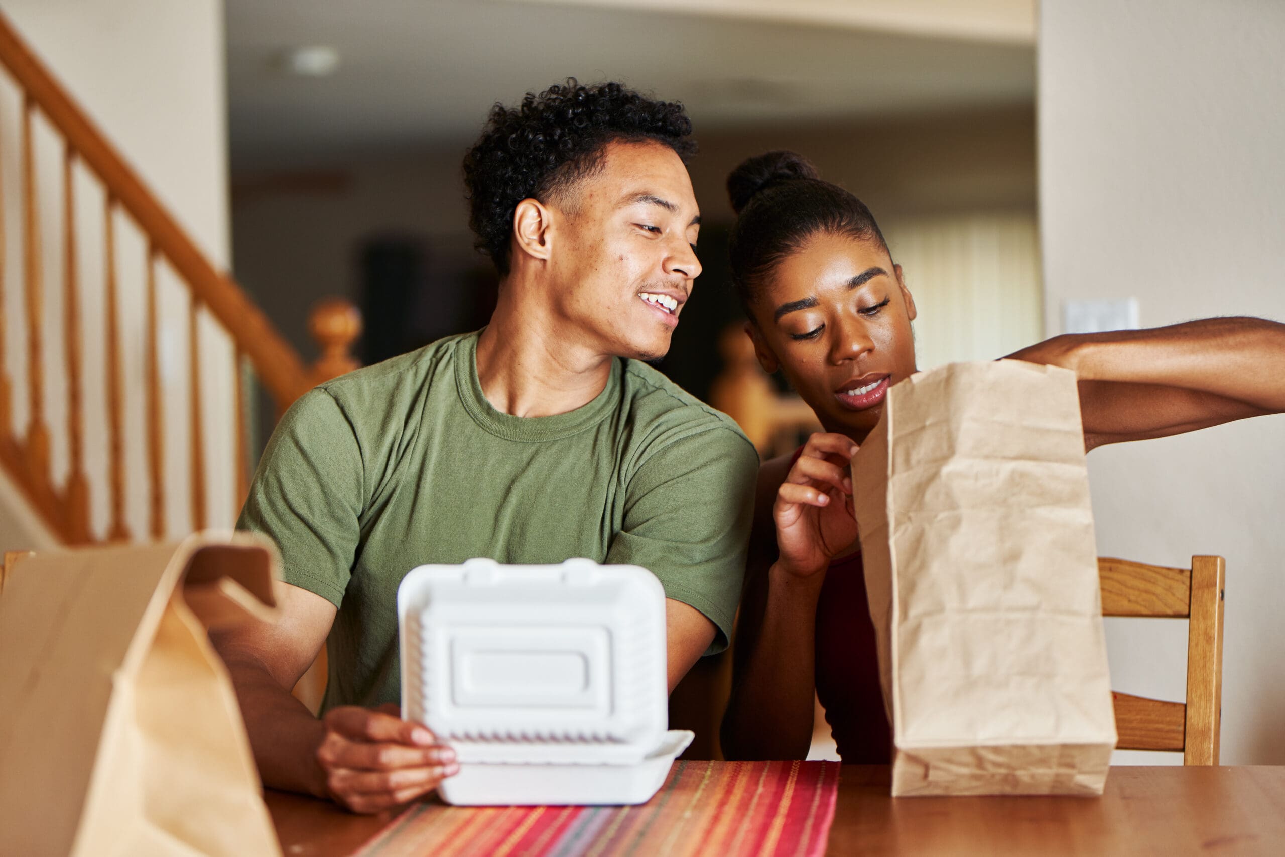 African,American,Couple,Sitting,At,Table,Looking,At,Food,Delivery